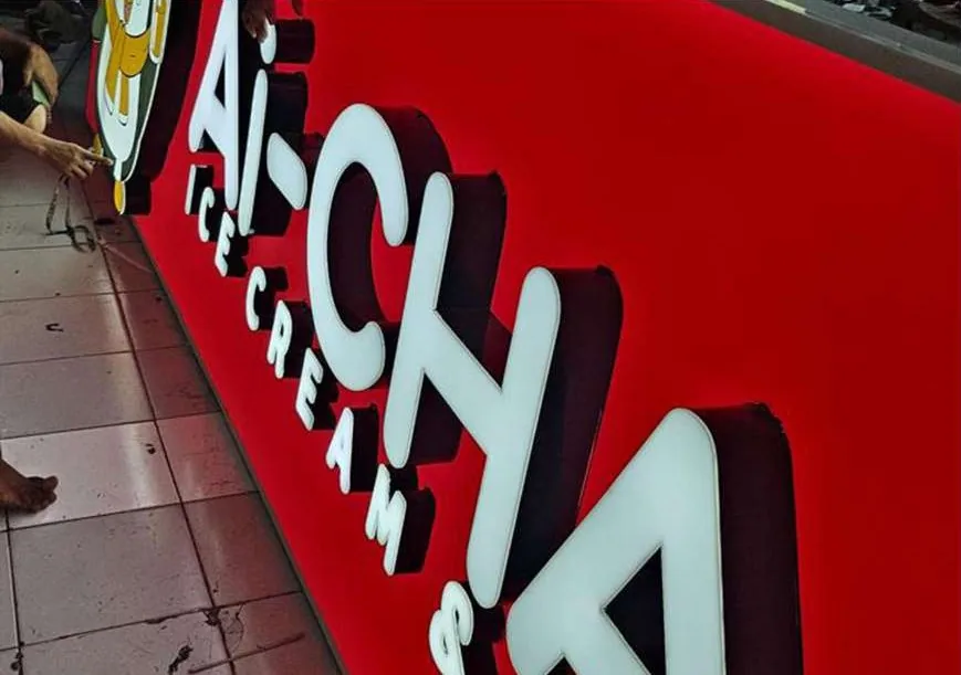 Ai-Cha sign with raised white letters on red