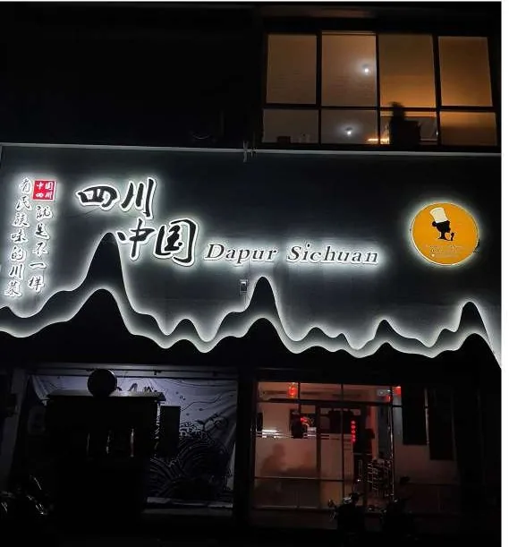 Dapur Sichuan lit outline signage across a restaurant front