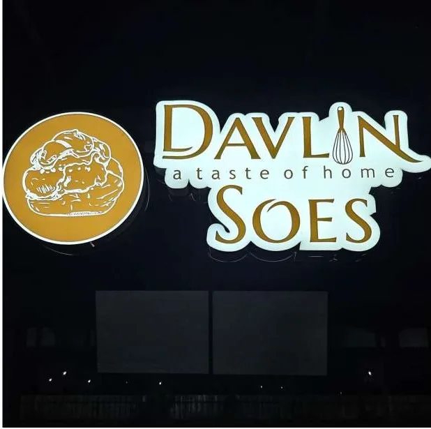 Davlin Soes lit emblem and wordmark at night