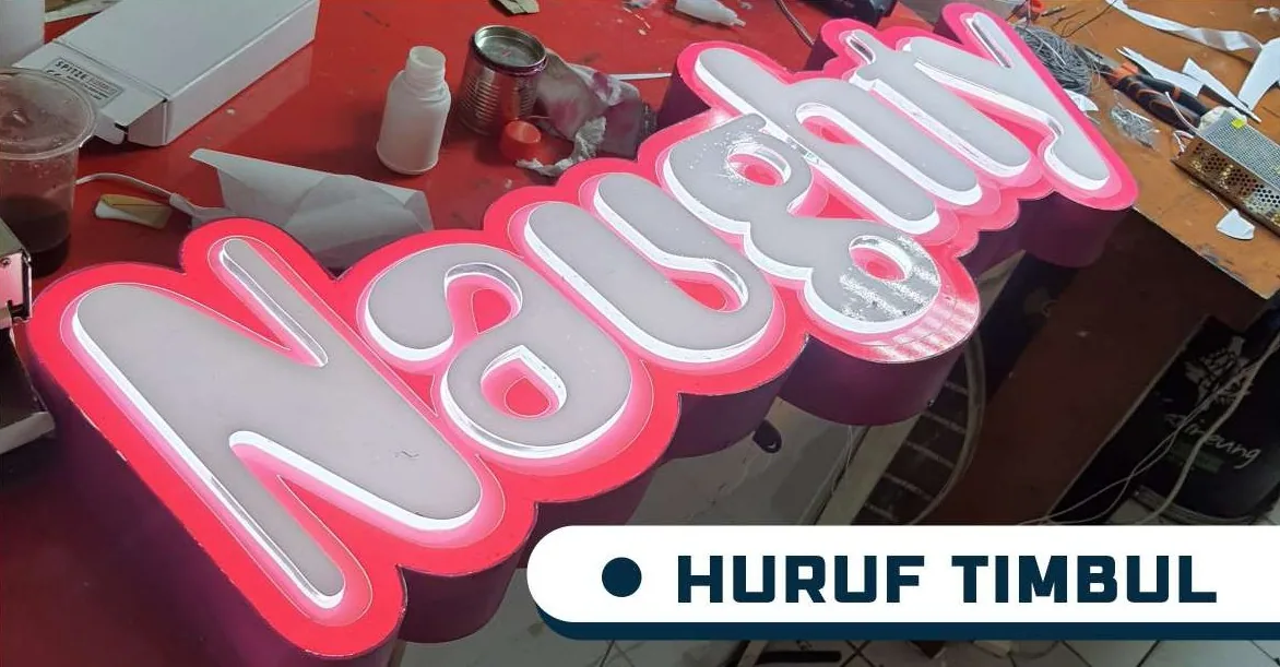 Naughty pink dimensional letters on a workbench