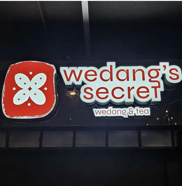 Wedang's Secret lit sign at night